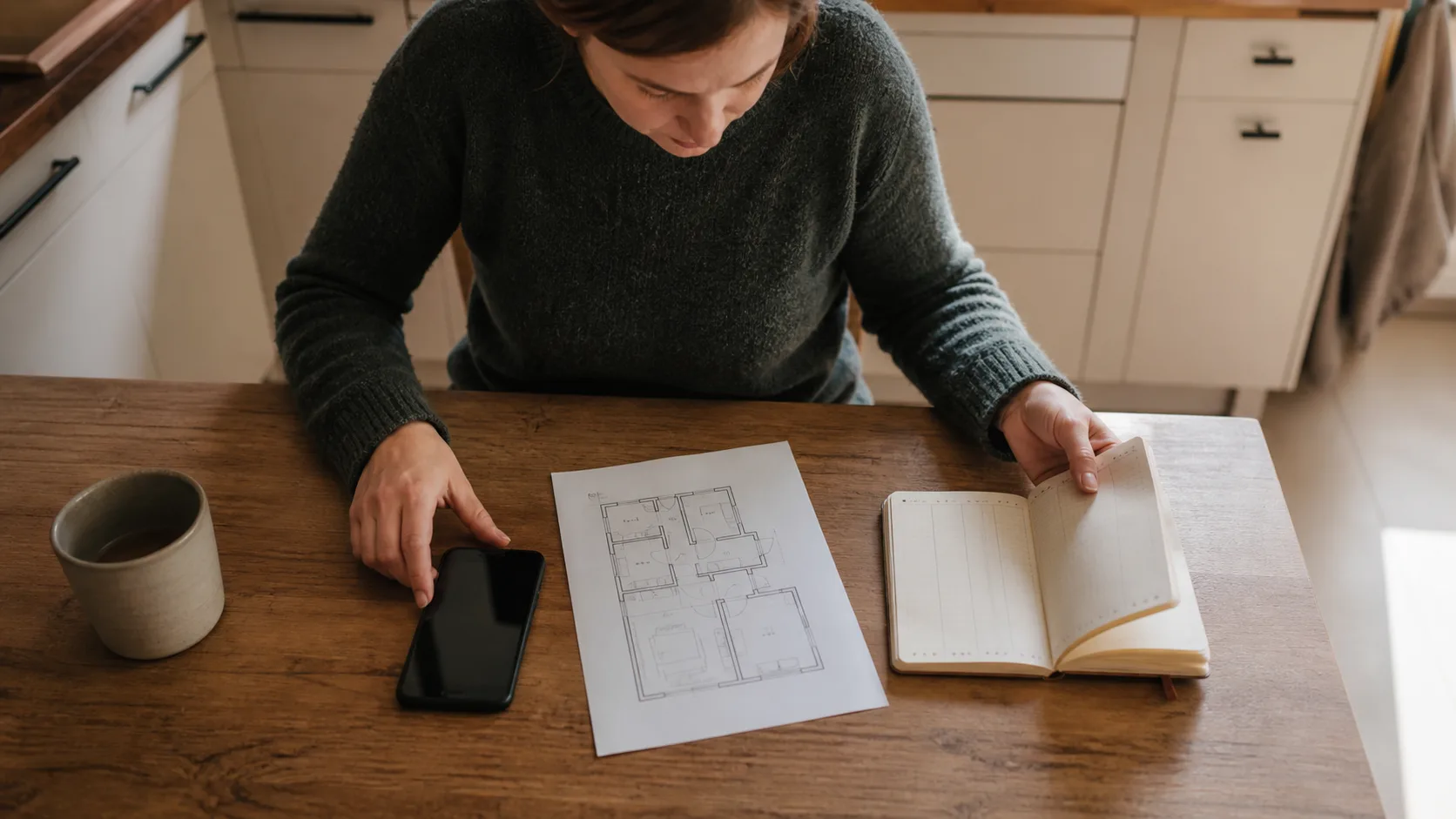 Résidente organisant un téléphone, un carnet et un plan de logement pour un relevé d’observations